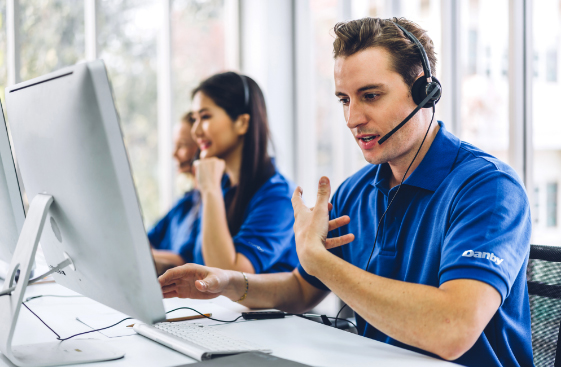 Un représentant du service client de Danby Appliances portant un casque, assistant à un poste de travail informatique dans un bureau lumineux