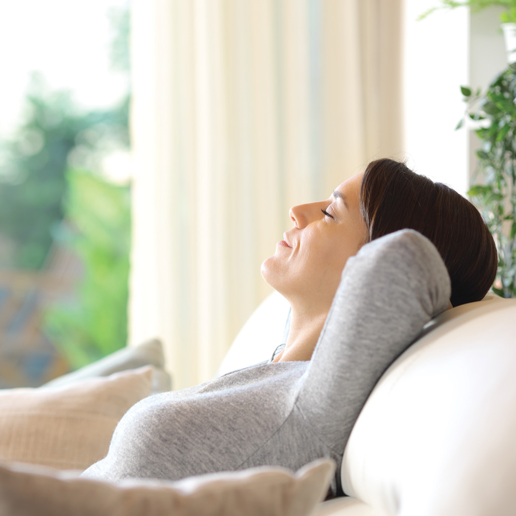 Danby appliances air purifier 210 sq ft used in a living room setting with a person relaxing indoors and natural light from a window