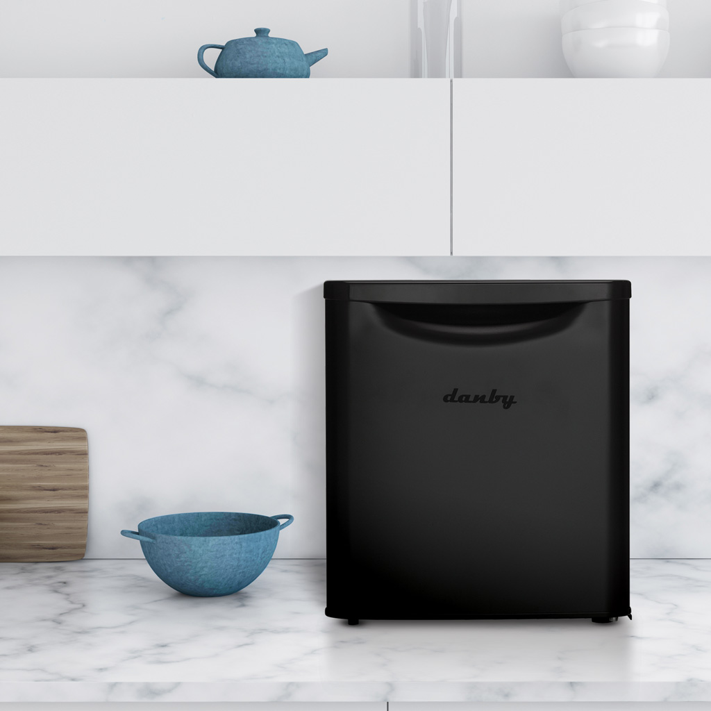 Danby appliances 1.7 cu ft compact fridge black DAR017A3BDB shown on a kitchen countertop beside dishes and décor, highlighting compact size and everyday use