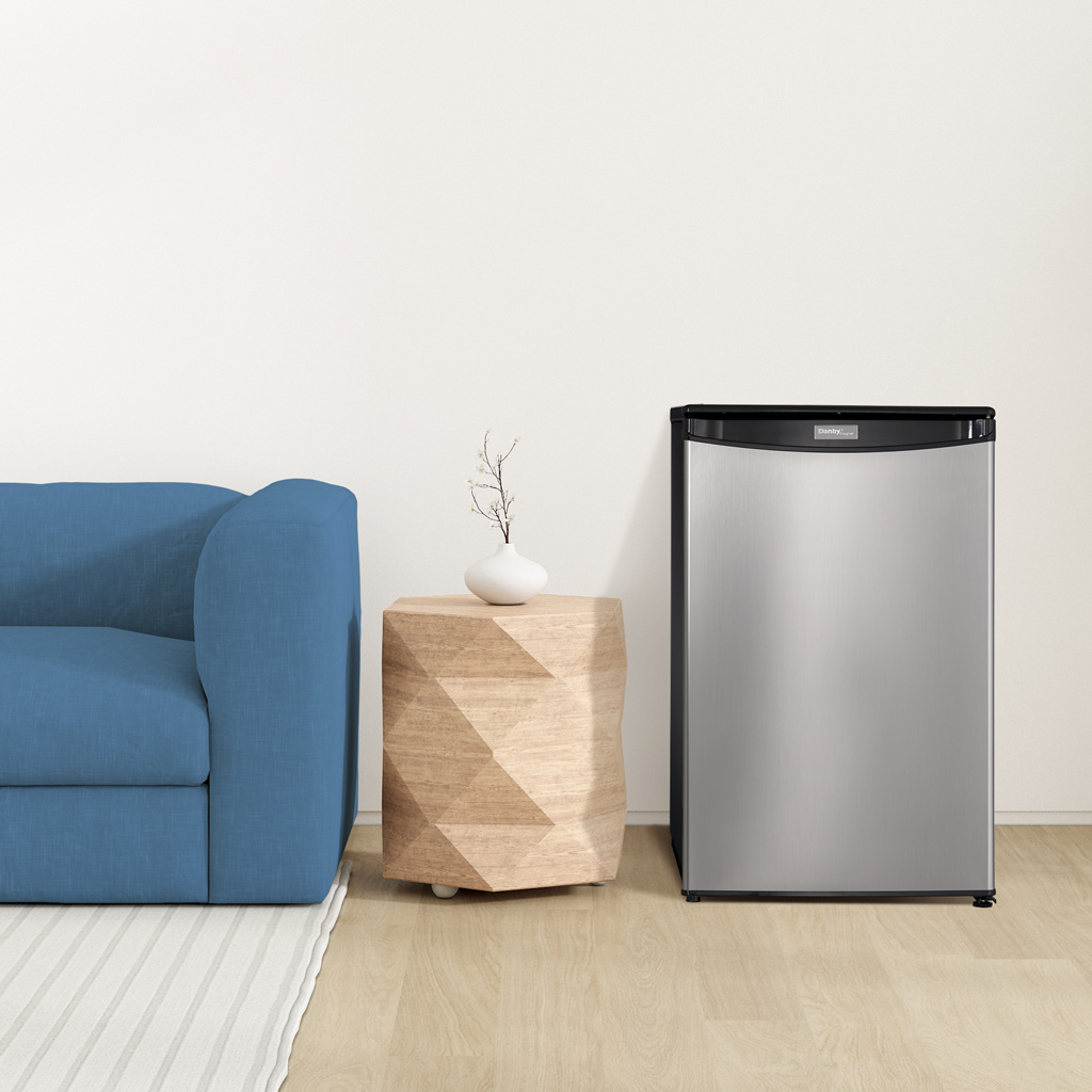 Danby appliances 4.4 cu ft compact fridge stainless DAR044A4BSSDD shown in a living room beside a sofa and side table highlighting compact placement and everyday use