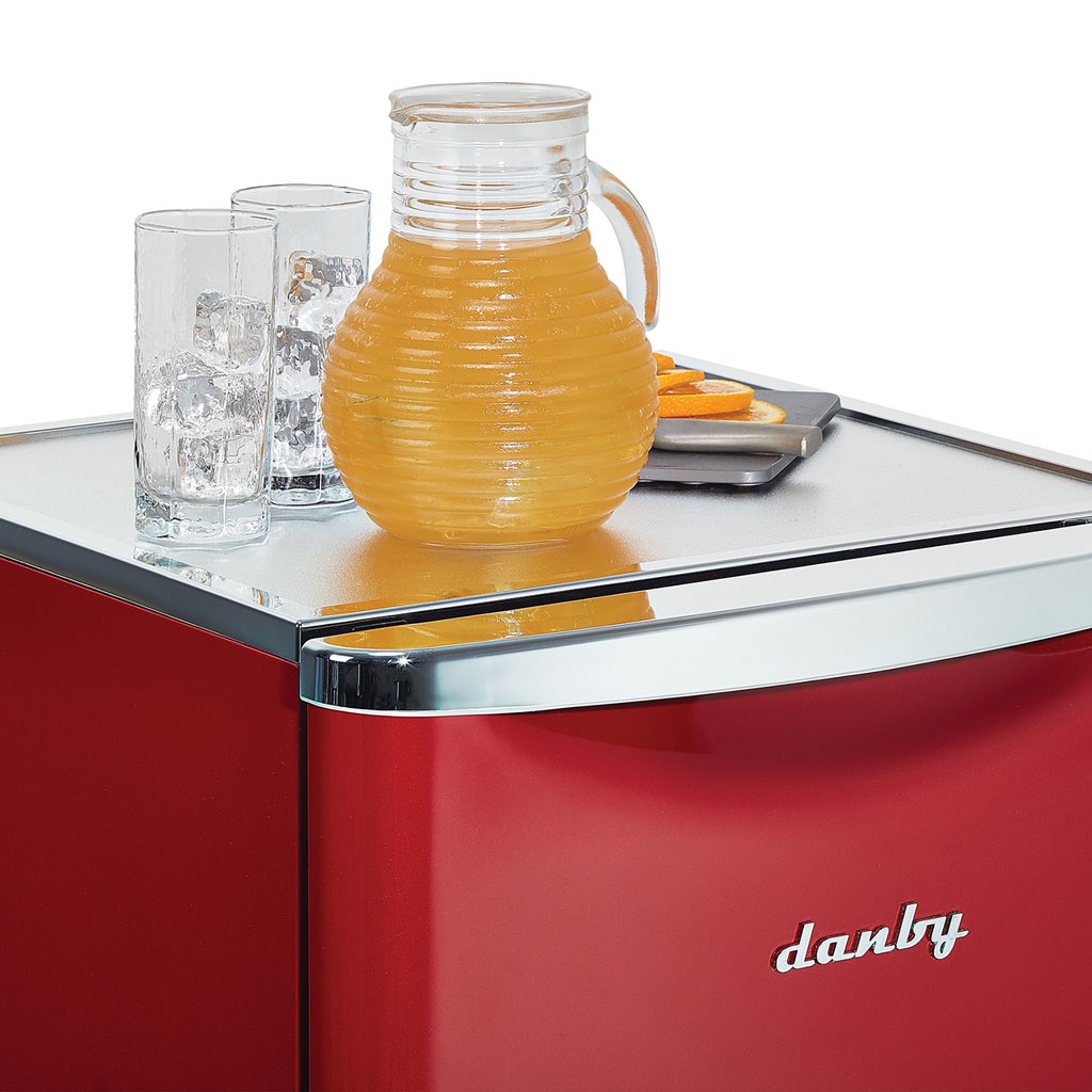 Danby appliances 4.4 cu ft compact fridge red DAR044A6LDB close-up of top surface with glass pitcher and cups highlighting usable worktop space