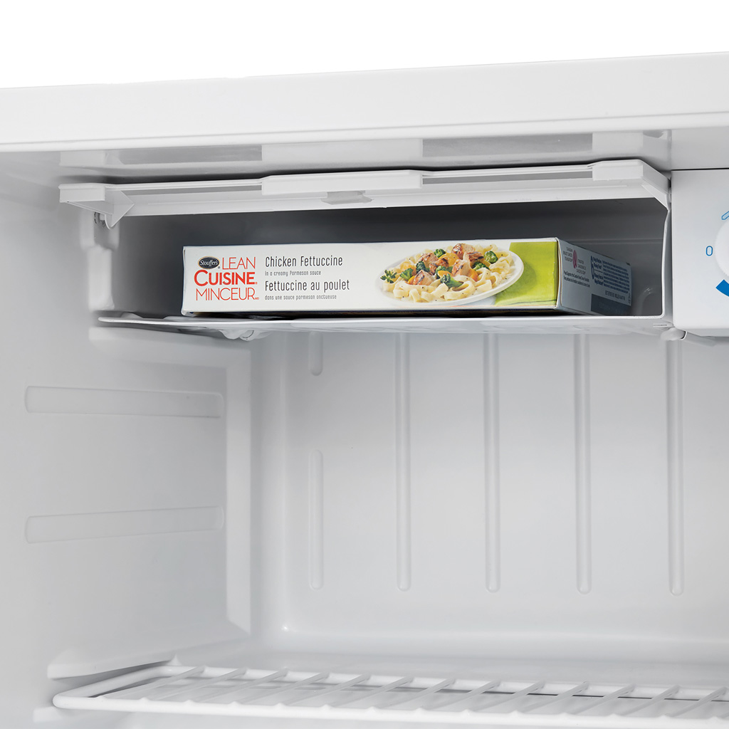 Danby appliances 1.6 cu ft compact fridge white DCR016A3WDB close-up of interior freezer section with packaged meal on top shelf and control dial visible