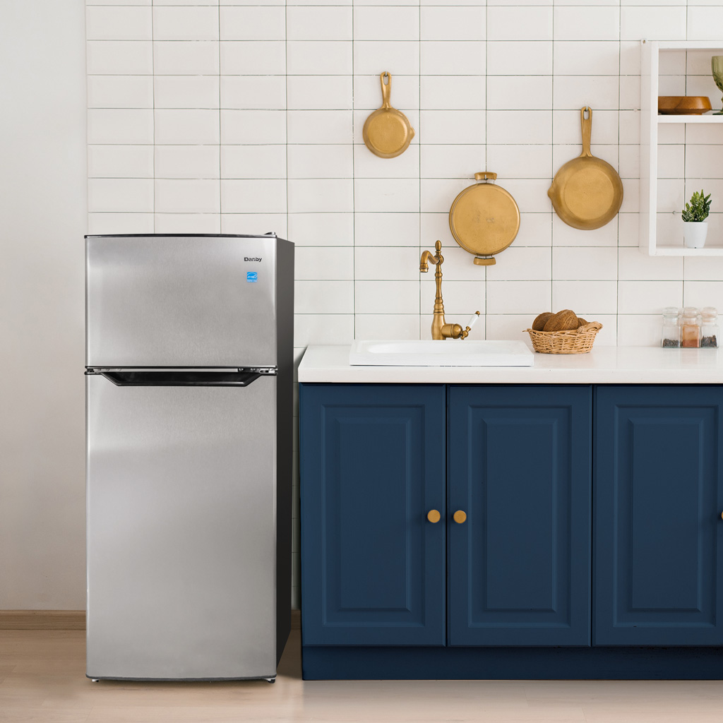 Danby appliances 4.5 cu ft compact fridge stainless DCR045B1SLDB 2 door shown in a kitchen setting beside blue cabinetry and backsplash highlighting compact placement and everyday use