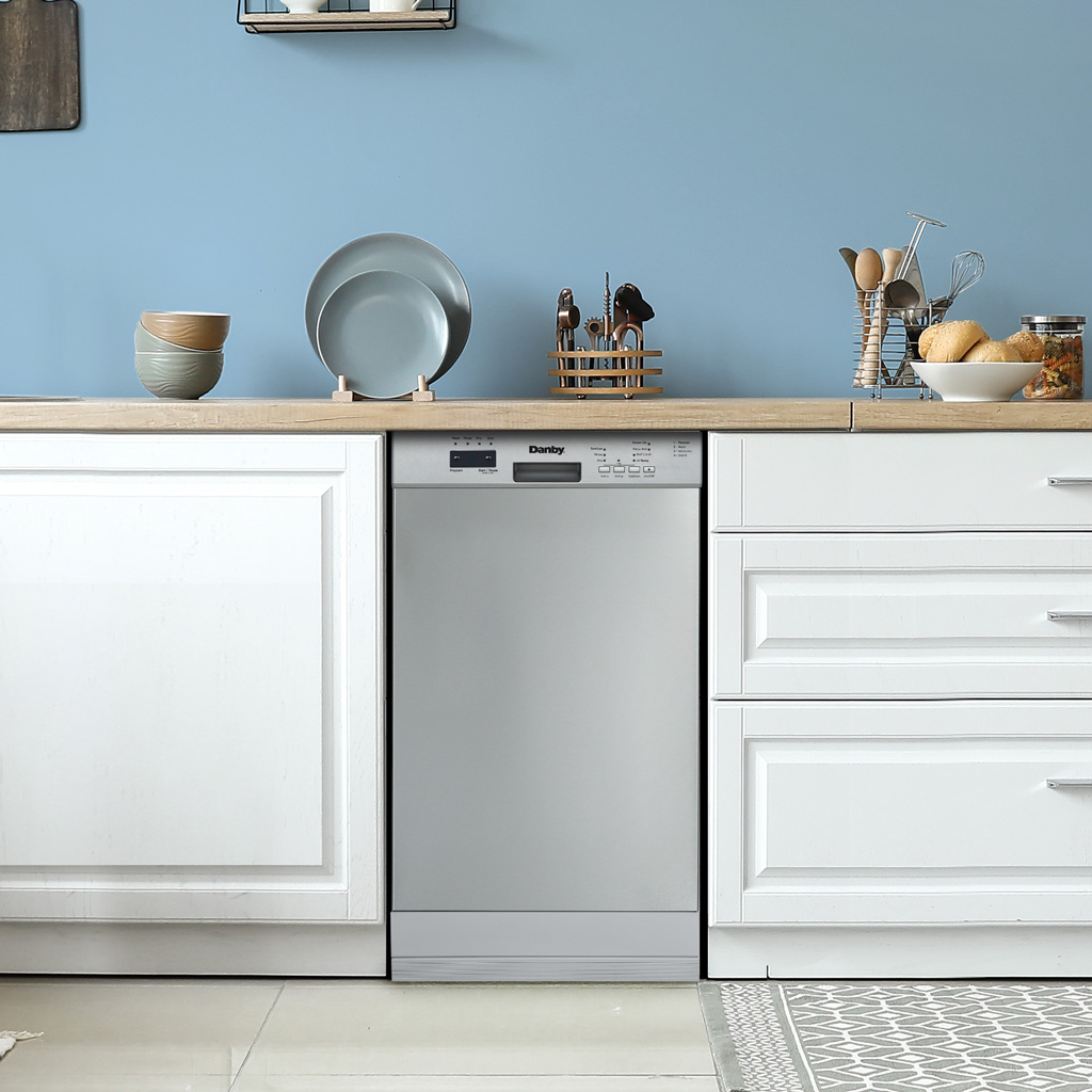 Danby appliances 18 inch built in dishwasher stainless steel DDW18D1ESS installed in a modern kitchen with white cabinets and wooden countertop shown in a front view