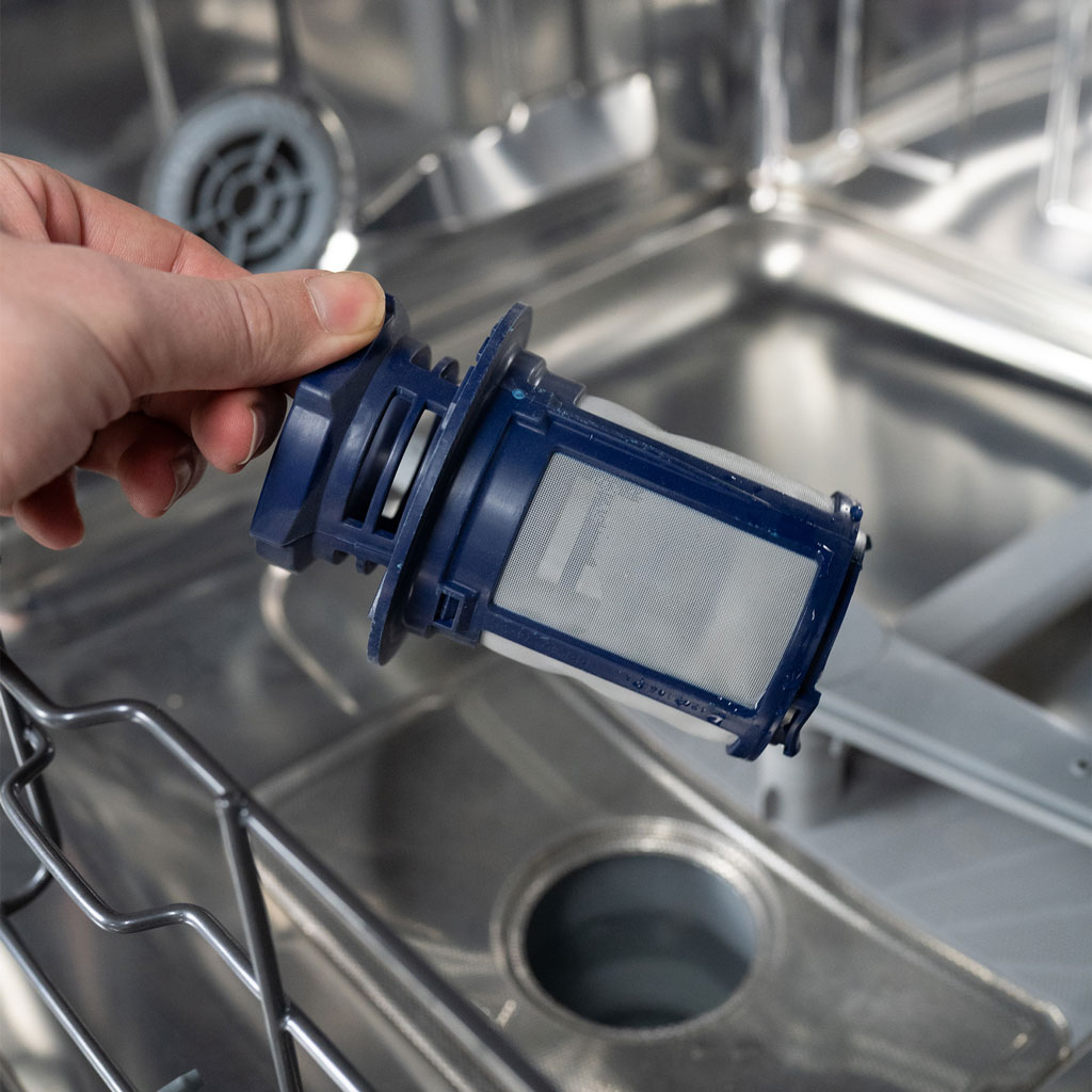 Danby appliances 24 inch built in dishwasher DDW2400ESS removable filter being cleaned by hand inside bottom compartment in close-up vie
