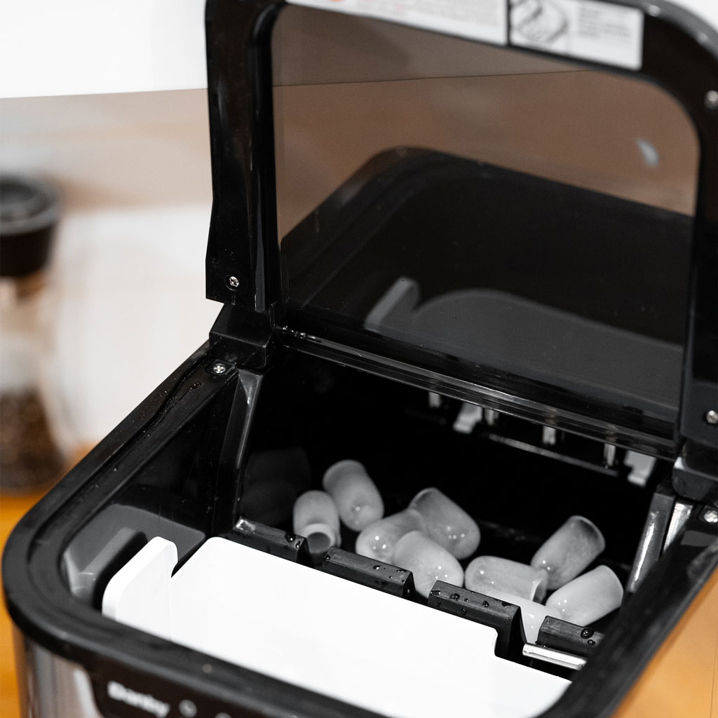 Danby DIM2500SSDB 25 lbs ice maker with lid open showing ice basket and interior compartment
