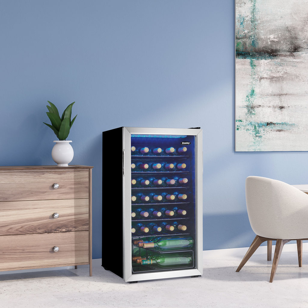 Danby 36 Bottle Free-Standing Wine Cooler in Stainless Steel 5 Danby appliances 36 bottle wine cooler stainless DWC036A1BSSDB-6 shown in a kitchen setting beside cabinetry and countertop with wine bottles visible through glass door