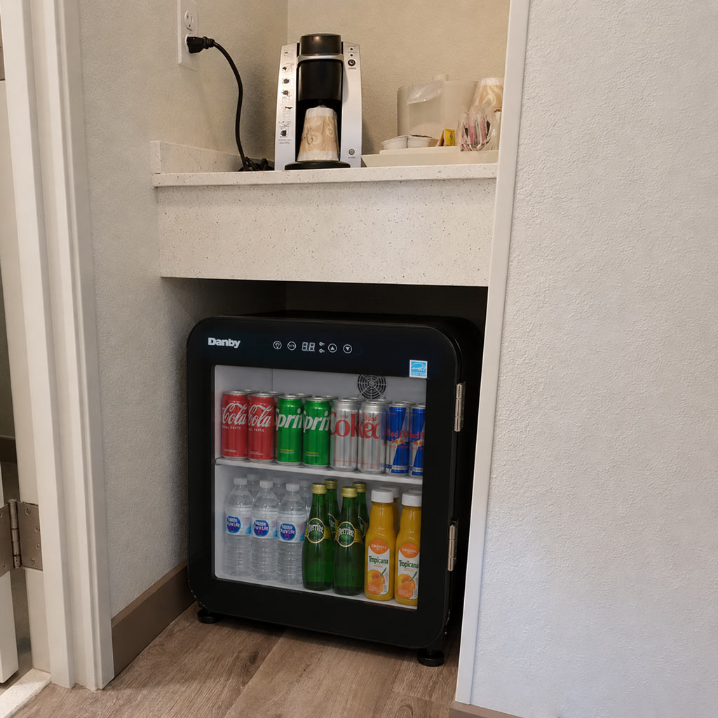 Danby DAG016A5BDH 1.6 cu ft glass door mini refrigerator in home setting with beverage storage