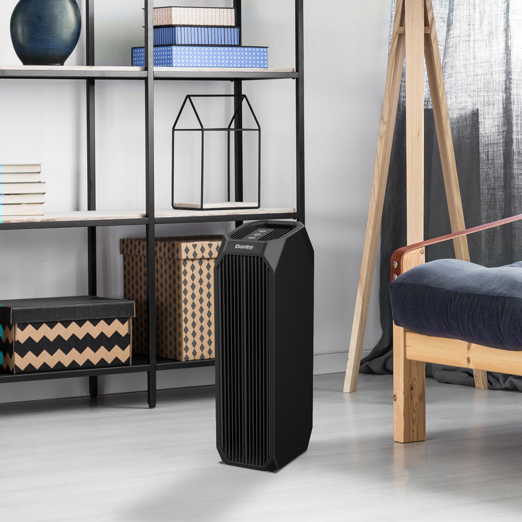 Danby DAP143BAB-UV air purifier in living room setting beside chair with modern decor