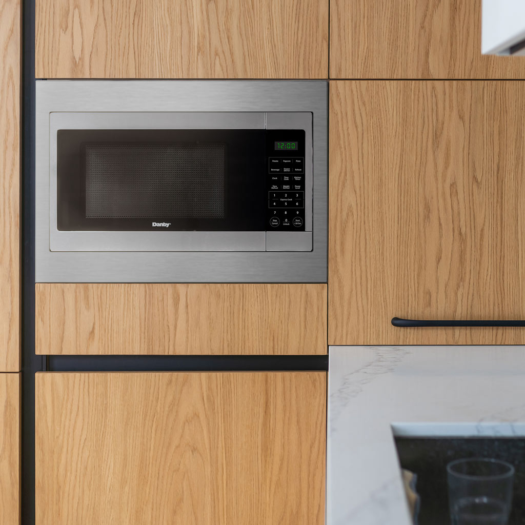 Danby DMW16A1SSDB 1.6 cu ft countertop microwave installed in kitchen cabinetry with built-in appearance