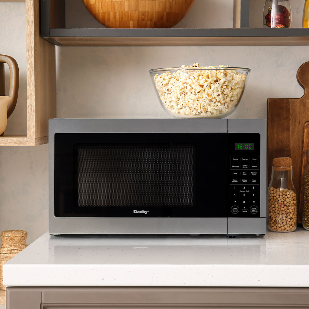 Danby DMW16A1SSDB 1.6 cu ft countertop microwave installed in kitchen cabinet opening above countertop