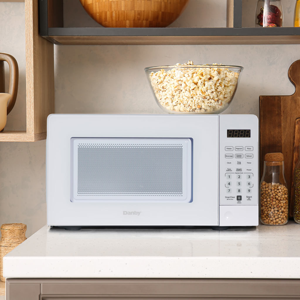 0.7 cu. ft. Countertop Microwave – 700 W 6 Danby DMW071A1W 0.7 cu ft countertop microwave heating food in kitchen setting