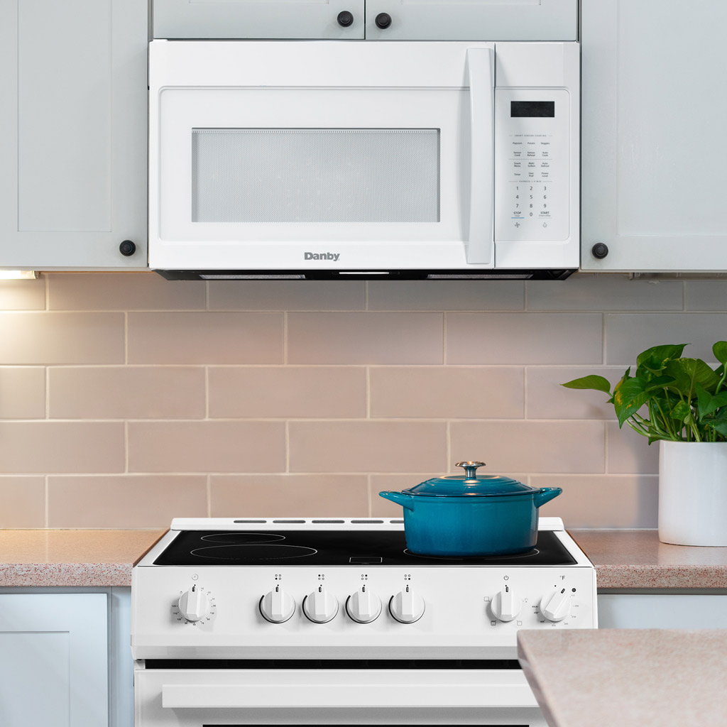 Danby DOM1742B1WDB 1.7 cu ft over range microwave installed above range in modern kitchen setting