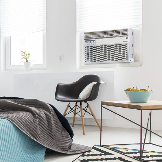 Window air conditioner installed in bedroom demonstrating the benefits of window air conditioner cooling for home comfort