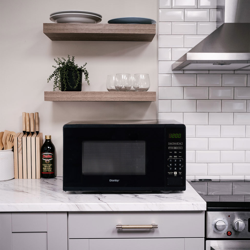 Danby DMW091A1B 0.9 cu ft countertop microwave in kitchen setting on countertop